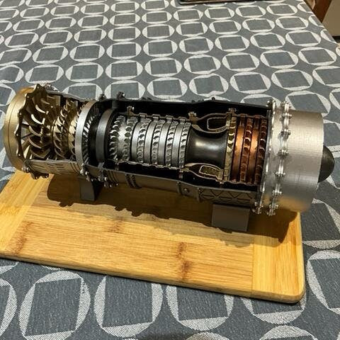 Finished 1:20 WS-15 turbofan model with a cutaway body on a wooden board.