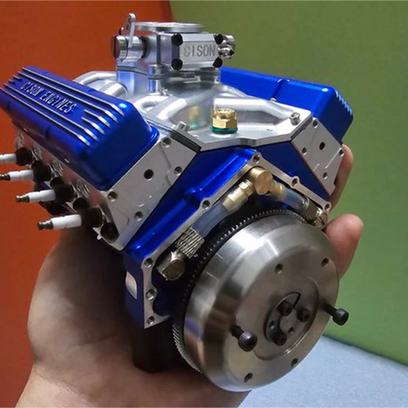 A hand holding a V8 engine model kit.