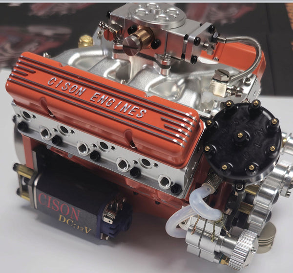 CISON miniature V8 engine model viewed from the flywheel side with visible exhaust headers and ignition components